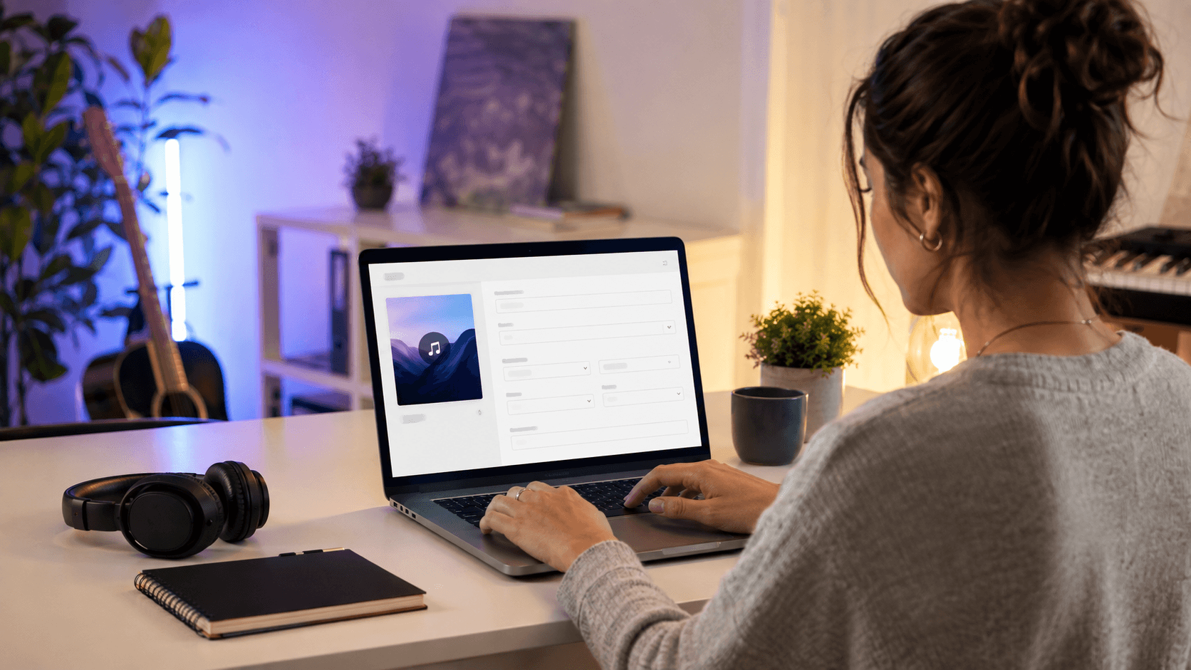 Music creator editing an MP3's title, artist, album, and cover artwork on a laptop